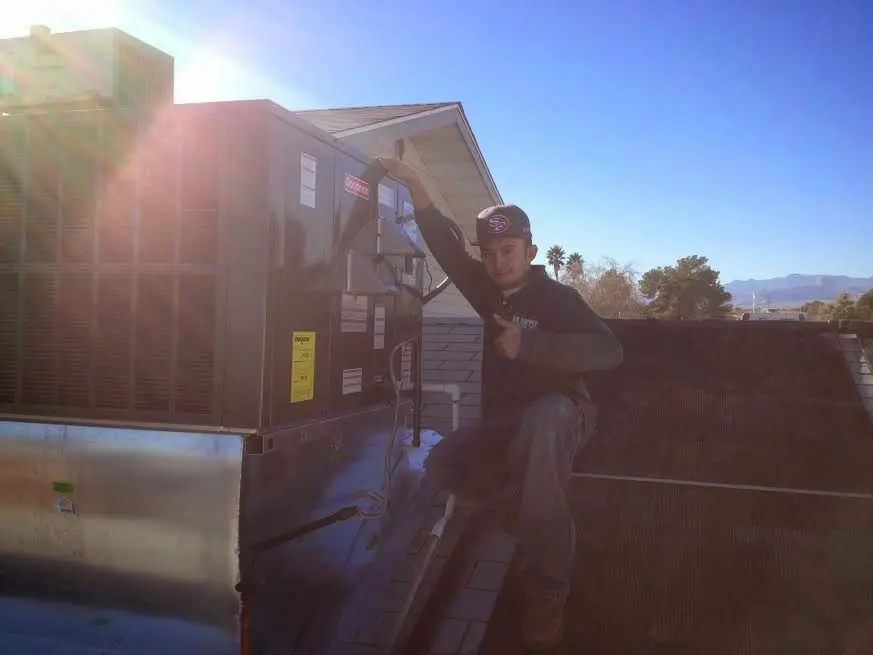 HVAC technician performing AC Tune-Up on a rooftop unit in Boonville